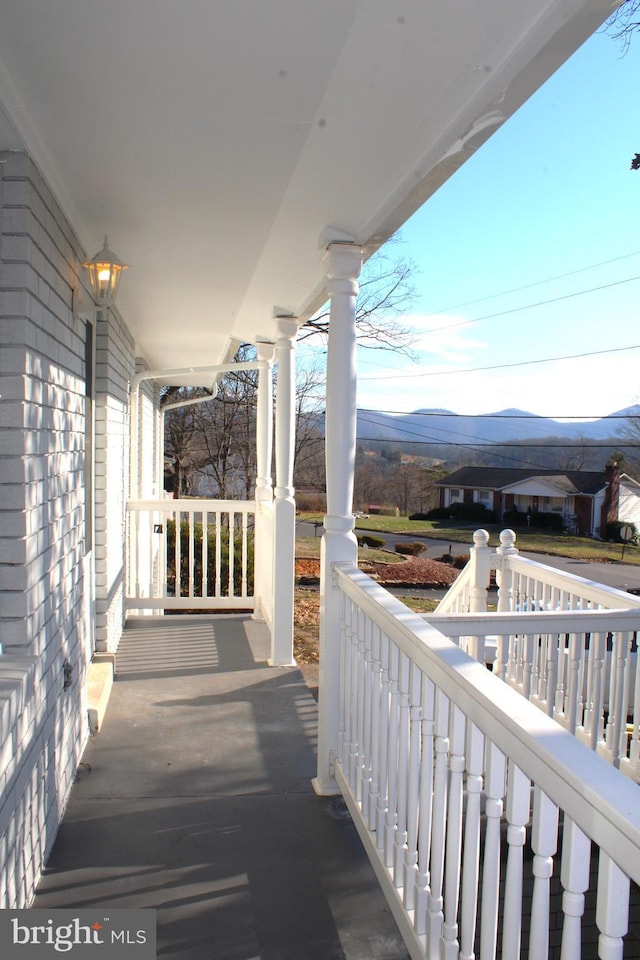 balcony featuring a mountain view and a porch