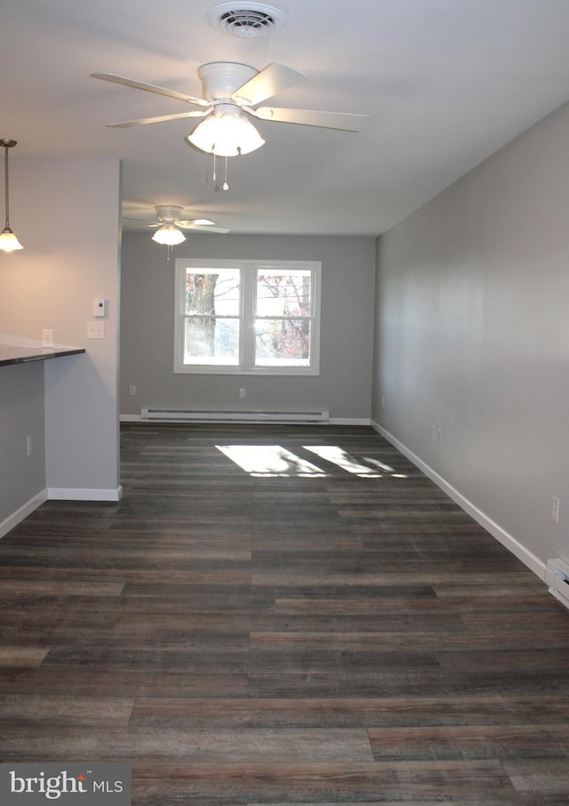 empty room featuring ceiling fan, dark hardwood / wood-style floors, and a baseboard heating unit