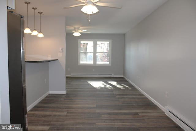 interior space with dark hardwood / wood-style floors, ceiling fan, and a baseboard heating unit