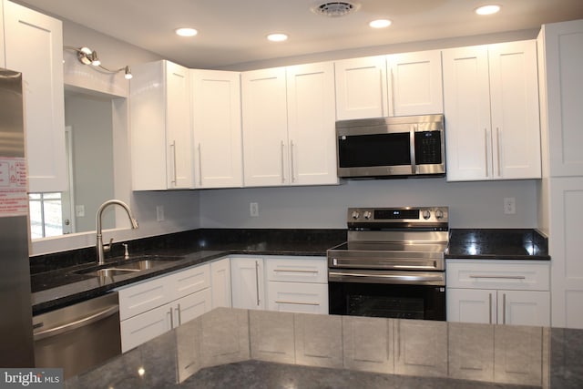 kitchen featuring white cabinets, stainless steel appliances, and sink