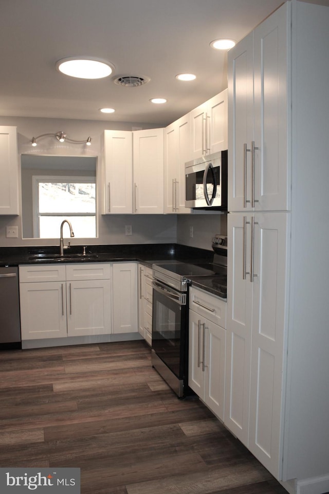 kitchen featuring sink, white cabinets, stainless steel appliances, and dark hardwood / wood-style floors