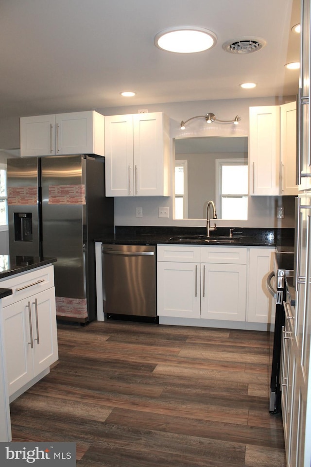 kitchen featuring dark hardwood / wood-style flooring, white cabinets, stainless steel appliances, and sink