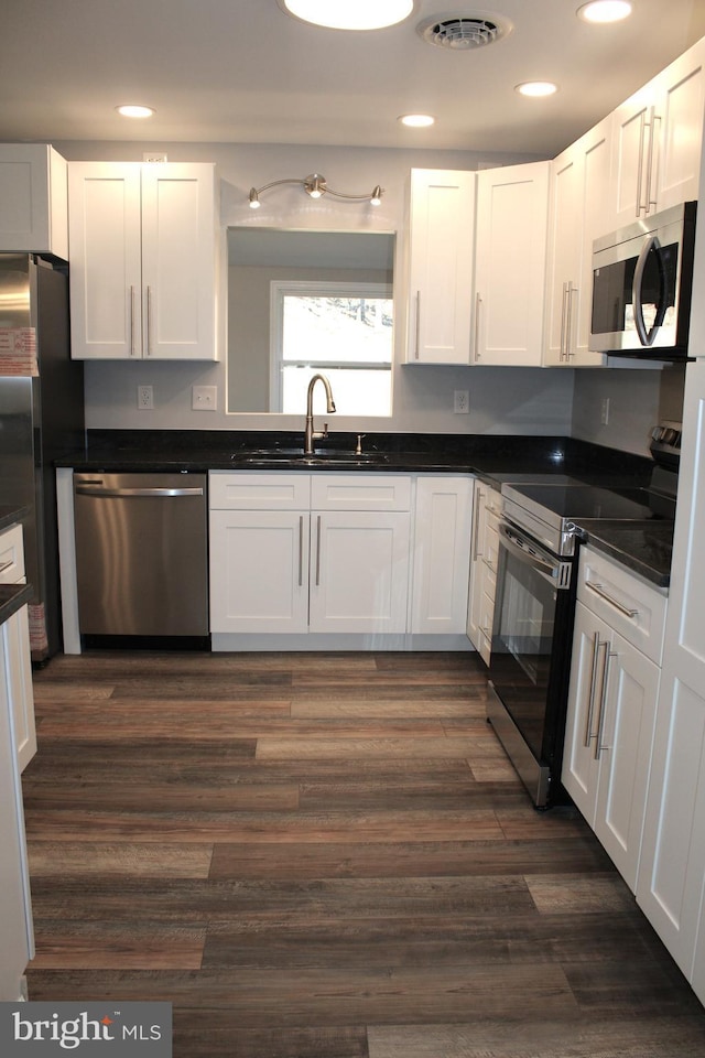 kitchen featuring sink, white cabinets, dark hardwood / wood-style floors, and appliances with stainless steel finishes