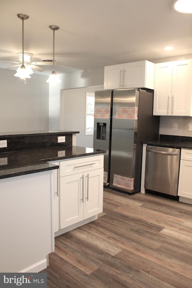 kitchen with dark hardwood / wood-style flooring, stainless steel appliances, ceiling fan, decorative light fixtures, and white cabinetry