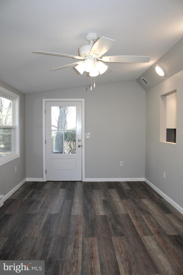 foyer entrance featuring ceiling fan, dark hardwood / wood-style flooring, and vaulted ceiling