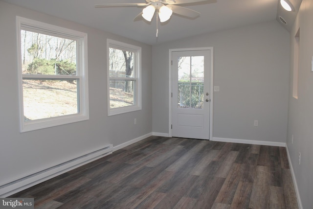 interior space featuring a wealth of natural light, dark hardwood / wood-style floors, vaulted ceiling, and baseboard heating