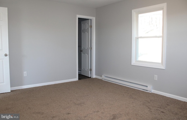 carpeted spare room featuring a baseboard heating unit