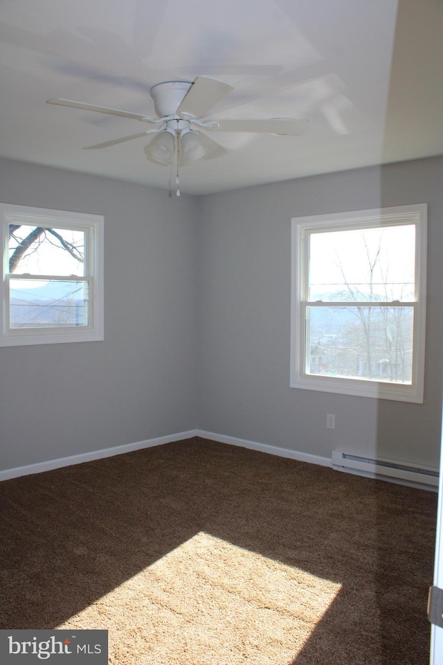 unfurnished room with dark carpet, ceiling fan, a healthy amount of sunlight, and a baseboard heating unit