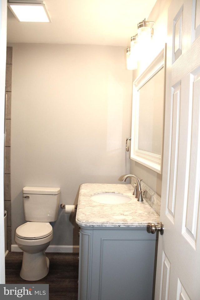 bathroom with hardwood / wood-style floors, vanity, and toilet