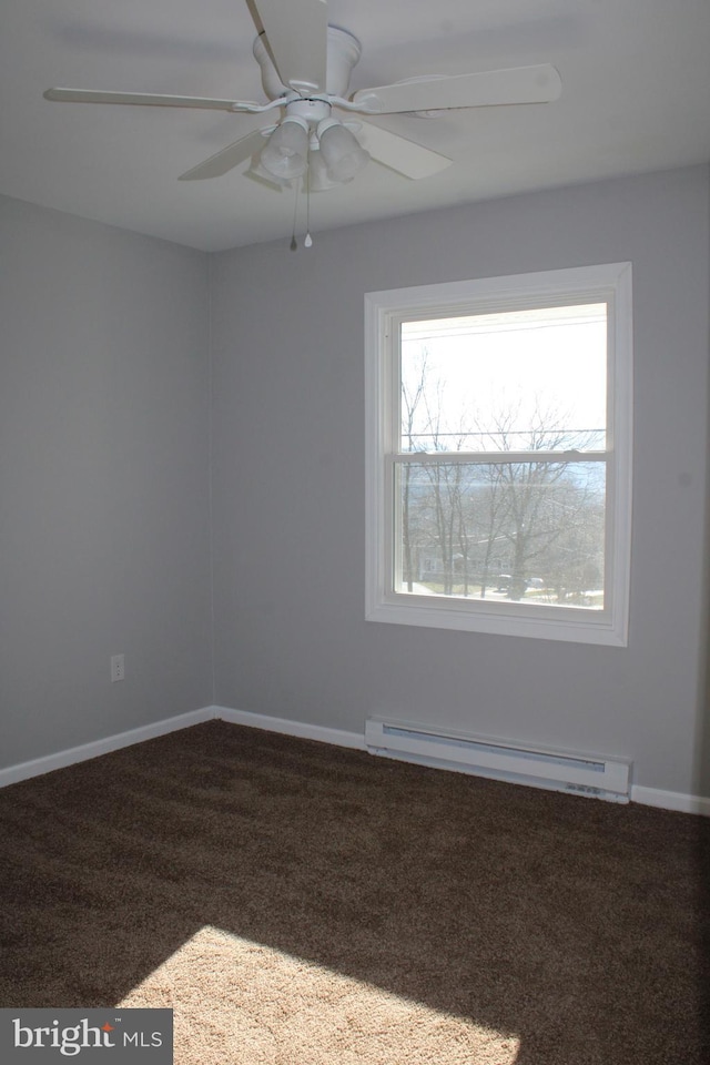 carpeted empty room featuring ceiling fan and a baseboard heating unit