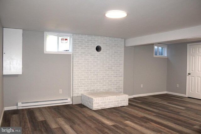 basement with baseboard heating and dark hardwood / wood-style floors