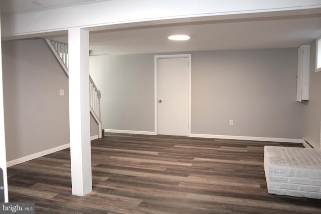 basement featuring dark hardwood / wood-style flooring and a baseboard radiator