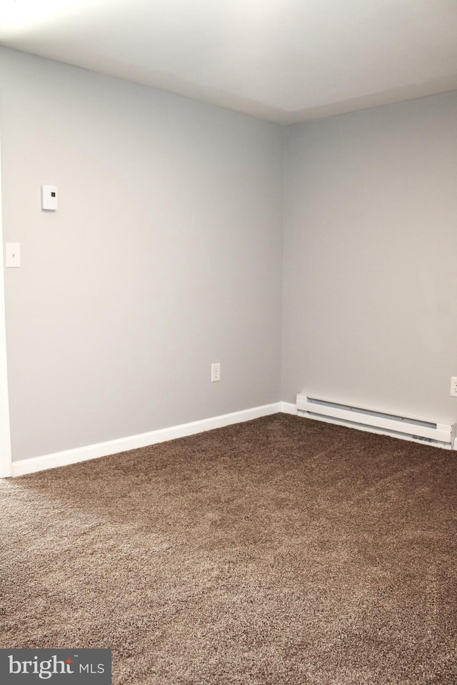 carpeted spare room featuring baseboard heating