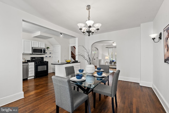 dining room with dark hardwood / wood-style flooring and ceiling fan with notable chandelier