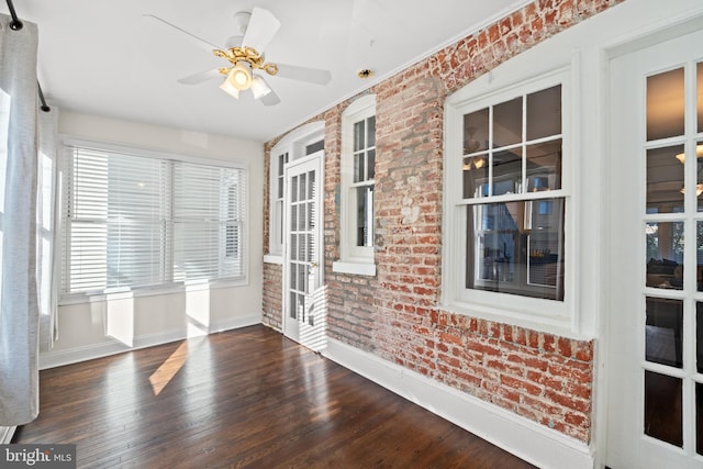 unfurnished sunroom featuring ceiling fan