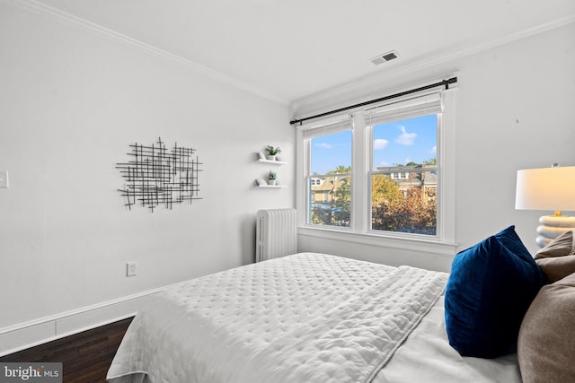 bedroom with dark hardwood / wood-style flooring, radiator heating unit, and ornamental molding