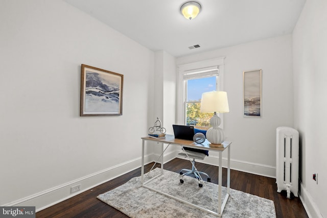 office area with radiator and dark wood-type flooring