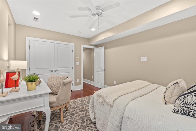 bedroom featuring a closet, dark wood-type flooring, and ceiling fan