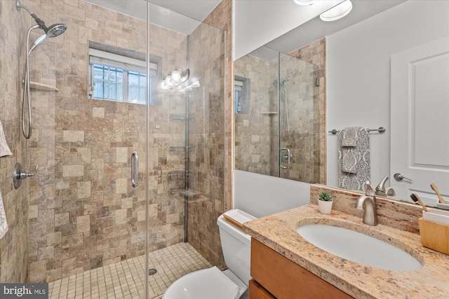 bathroom featuring vanity, an enclosed shower, and toilet