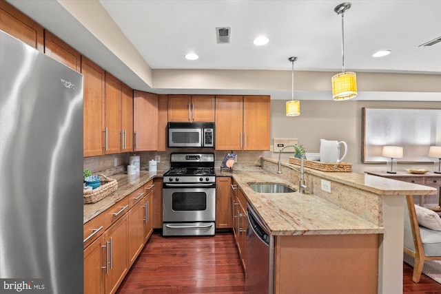 kitchen with kitchen peninsula, dark hardwood / wood-style flooring, a breakfast bar, stainless steel appliances, and pendant lighting