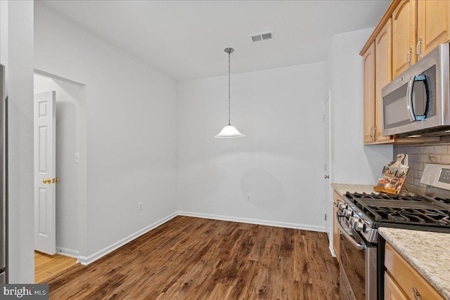 kitchen with tasteful backsplash, hanging light fixtures, light brown cabinets, dark hardwood / wood-style flooring, and stainless steel appliances