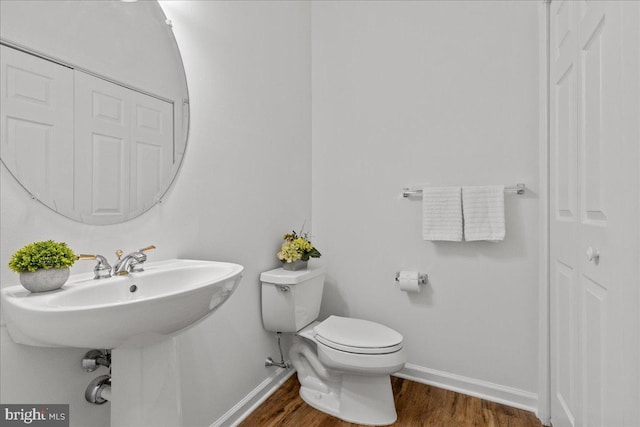 bathroom featuring hardwood / wood-style flooring and toilet