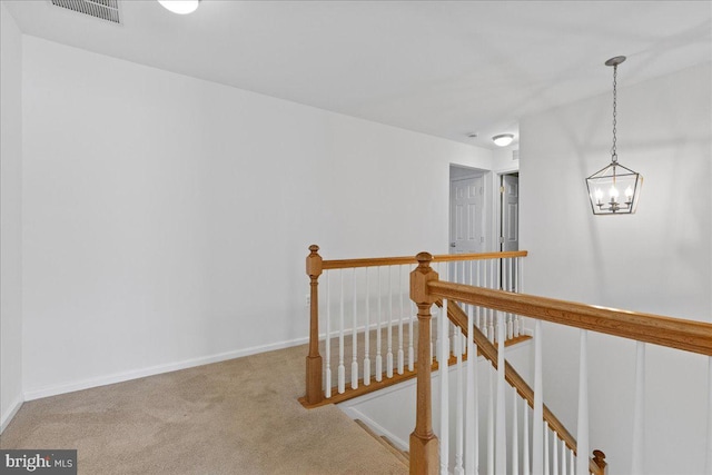 corridor featuring carpet flooring and a chandelier