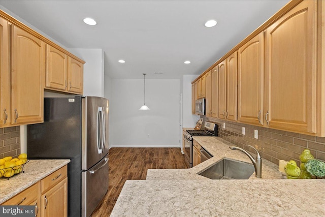 kitchen with sink, hanging light fixtures, stainless steel appliances, light stone counters, and dark hardwood / wood-style flooring