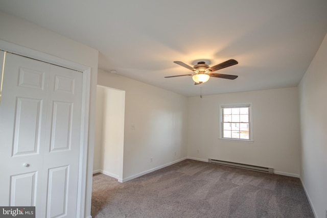 carpeted spare room featuring ceiling fan and a baseboard heating unit