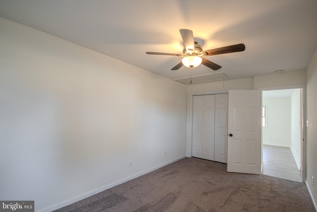 unfurnished bedroom with carpet flooring, ceiling fan, and a closet