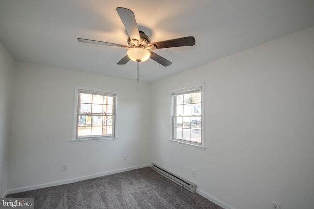 unfurnished room with dark colored carpet, ceiling fan, a healthy amount of sunlight, and a baseboard heating unit