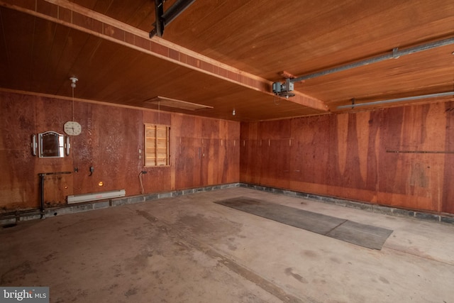 garage featuring wood ceiling, wooden walls, and a baseboard radiator