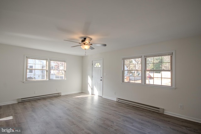 entrance foyer featuring hardwood / wood-style flooring, a healthy amount of sunlight, and a baseboard heating unit