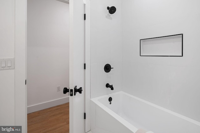 bathroom featuring tiled shower / bath combo and hardwood / wood-style flooring