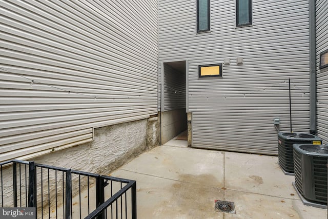 view of exterior entry featuring central AC unit and a patio area