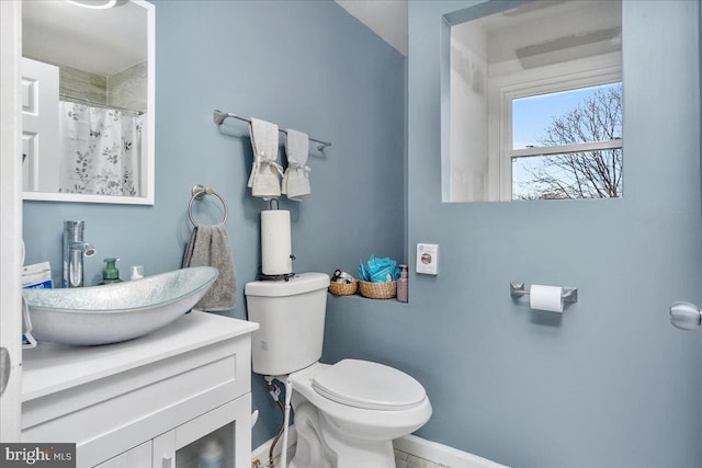 bathroom with walk in shower, vanity, and toilet