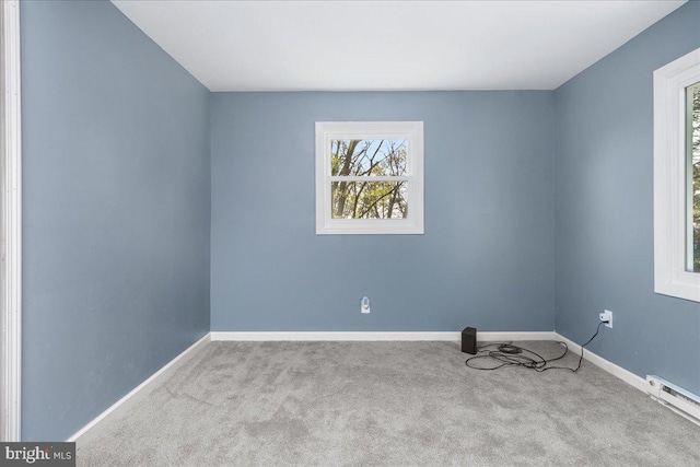 unfurnished room featuring light colored carpet and a baseboard heating unit