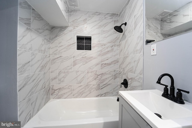 bathroom featuring vanity and tiled shower / bath