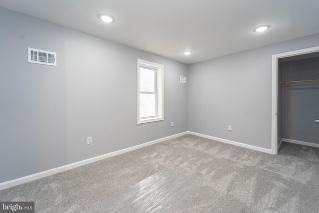 unfurnished bedroom with light carpet and a closet