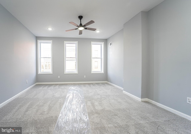 unfurnished room with ceiling fan and light carpet