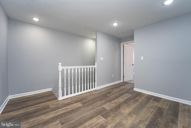 unfurnished room with dark wood-type flooring