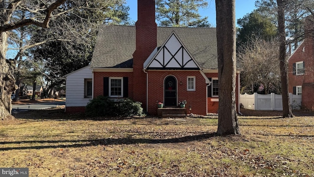 english style home featuring a front yard