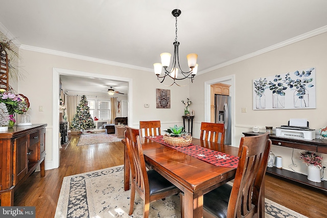 dining room with dark hardwood / wood-style floors, ornamental molding, and ceiling fan with notable chandelier