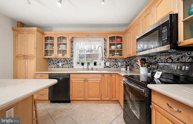 kitchen featuring black appliances, sink, light tile patterned floors, and backsplash