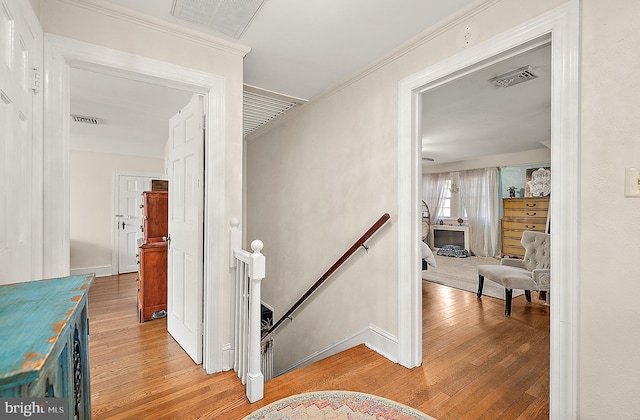 corridor featuring light hardwood / wood-style flooring and ornamental molding