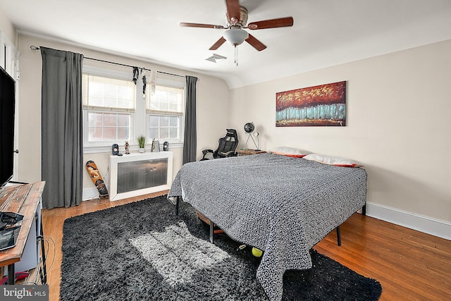 bedroom featuring ceiling fan, vaulted ceiling, and hardwood / wood-style flooring