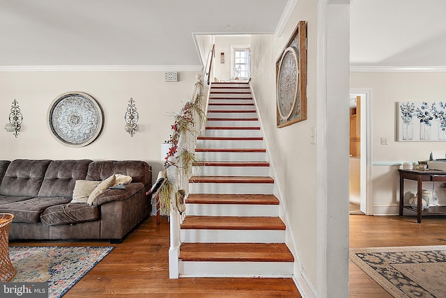 stairway with hardwood / wood-style flooring and ornamental molding