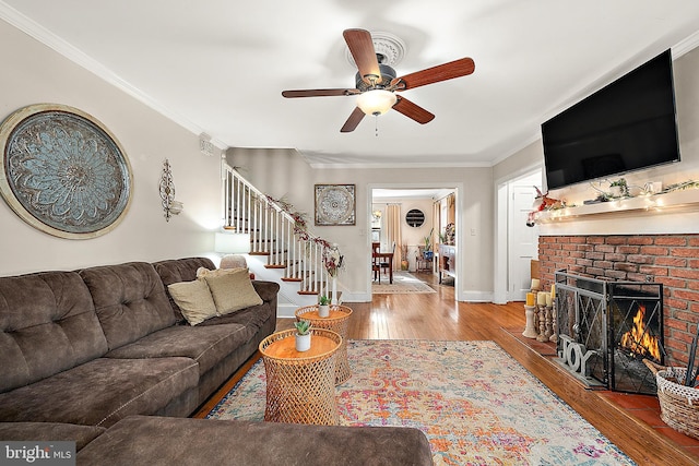 living room with a fireplace, ceiling fan, hardwood / wood-style floors, and ornamental molding