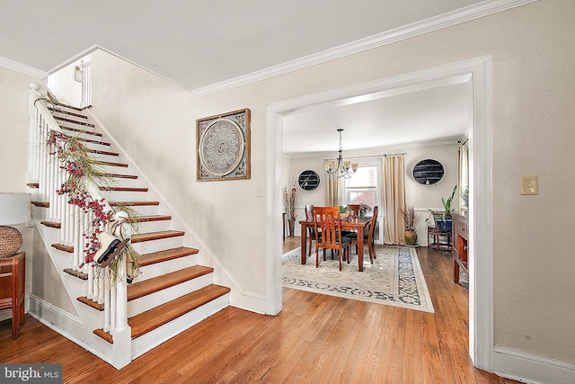 interior space with hardwood / wood-style flooring, an inviting chandelier, and crown molding