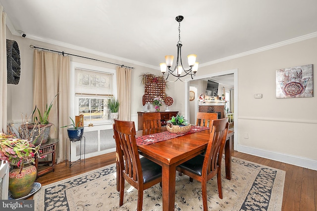 dining area with hardwood / wood-style floors, a notable chandelier, and ornamental molding